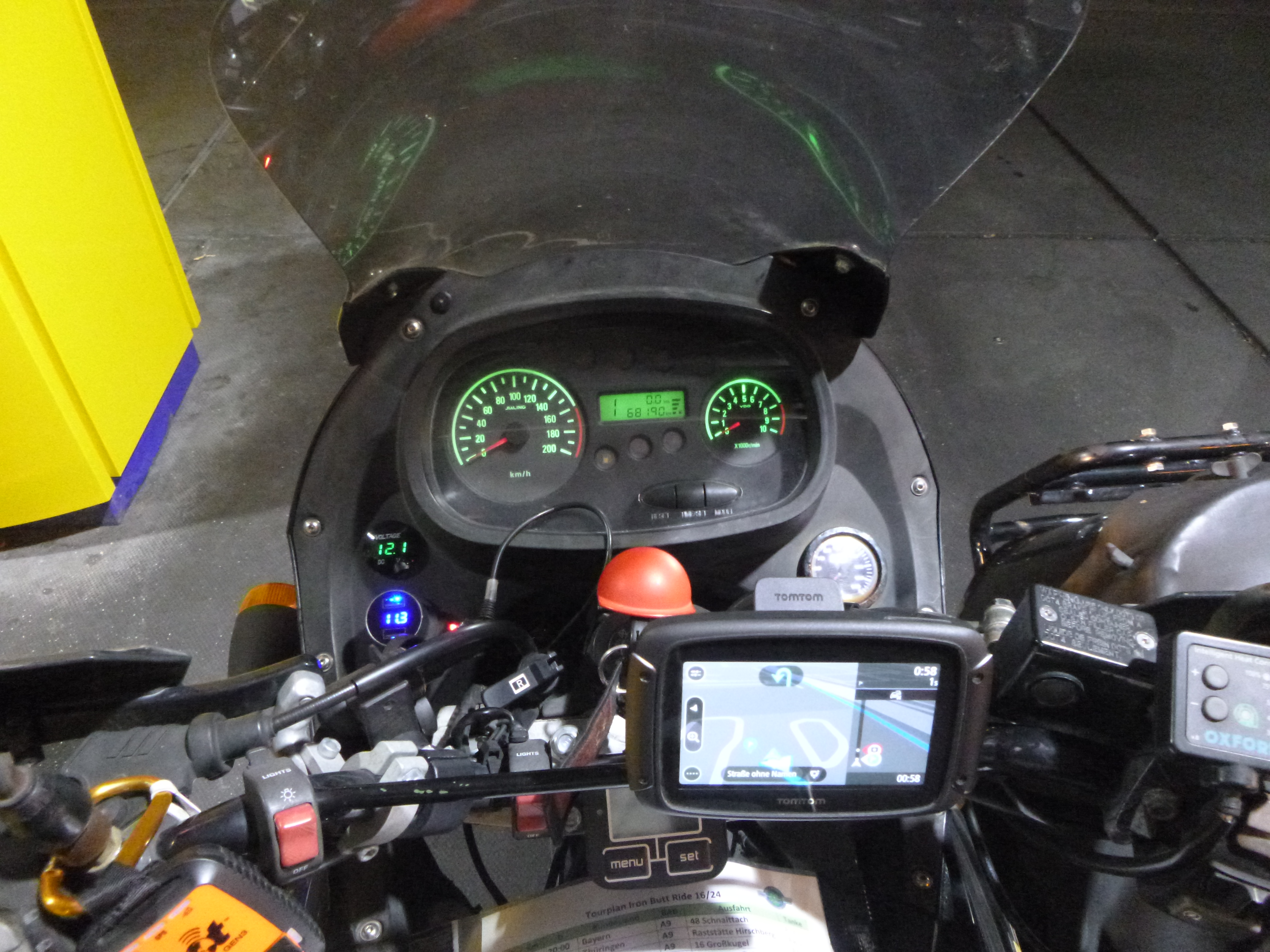Ein ausgewachsenes Cockpit, zusätzlich zur originalen Instrumententafel: 2x Voltmeter, Navi, GPS Tracker und Routeninformation auf Papier